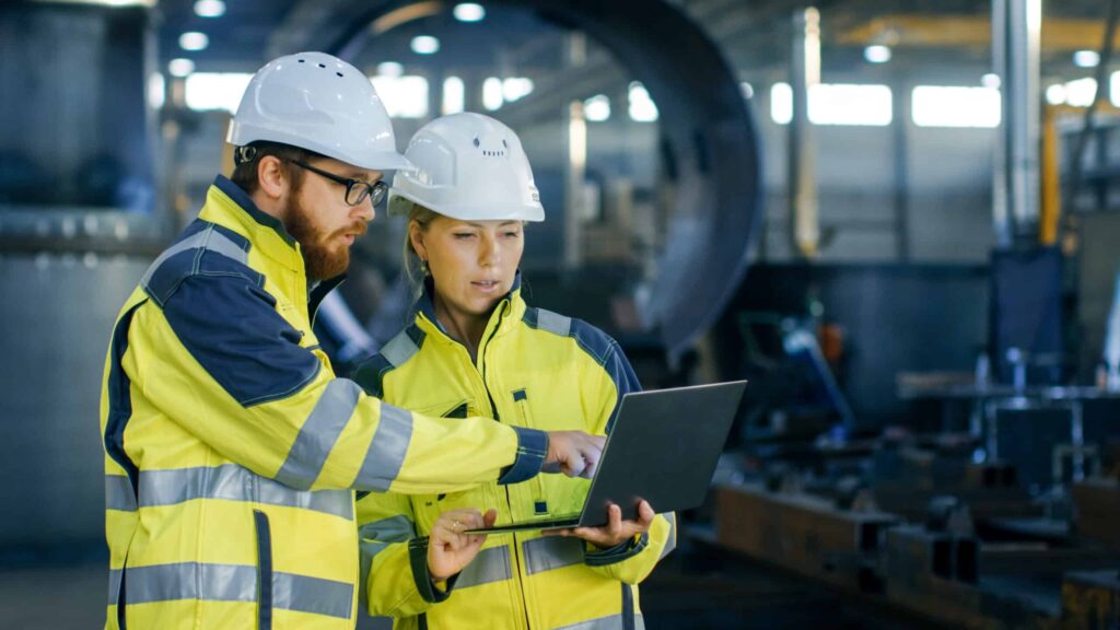 Vacatures bij de omgevingsdienst: twee inspecteurs met helm en klembord bij opslagtanks