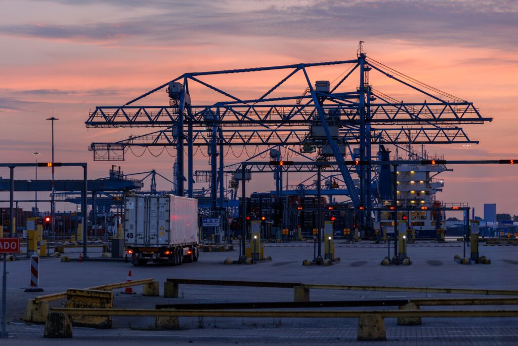 Vacatures bij Havenbedrijf Rotterdam: laadkranen in de haven bij zonsondergang
