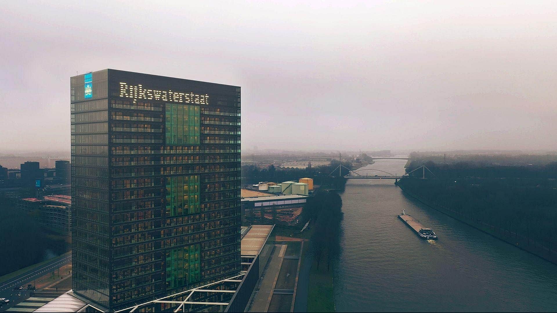 Rijkswaterstaat vacatures een inspecteur op een rijksweg langs een brug in aanbouw